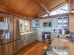 Beautiful kitchen with wood floors throughout and vaulted ceilings. Endless windows in this home.